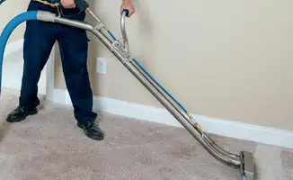 Professional operating a liquid removal machine on a carpeted floor in Anaheim, CA